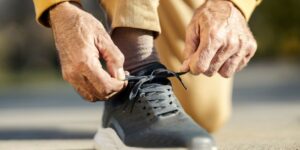 older man tying sneakers to exercise to prevent alzheimers symptoms