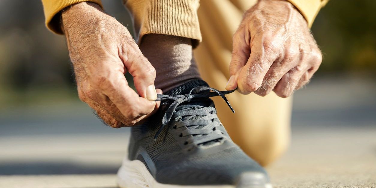 older man tying sneakers to exercise to prevent alzheimers symptoms