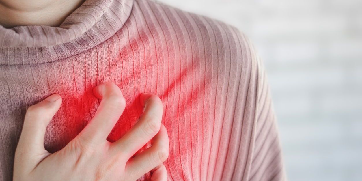 woman grasping at heart area